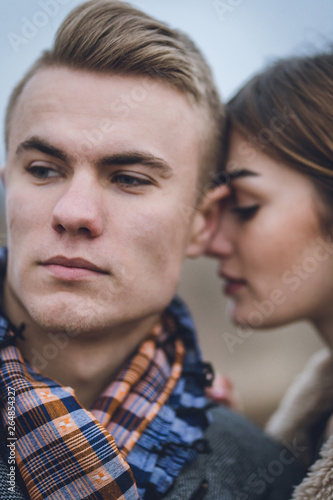 lovers close up emotional portrait. man hugs women. beautiful lovely fashionable trendy stylish couple hugging kissing. man in coat and scarf with woman in coat. lovers leaned touched foreheads