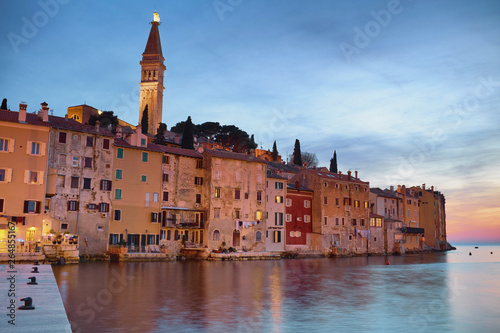 The beautiful Rovinj after sunset in the blue hour with the pier in Istria, Croatia.