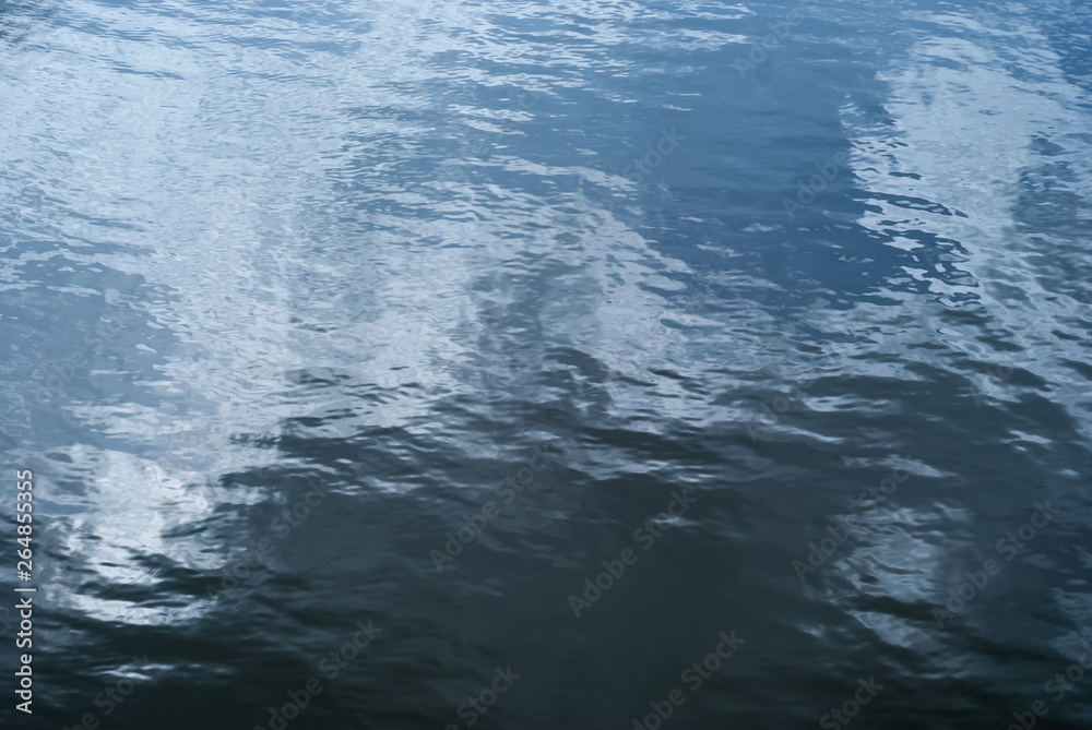 Obraz premium background - glossy water surface with waves and sky reflection