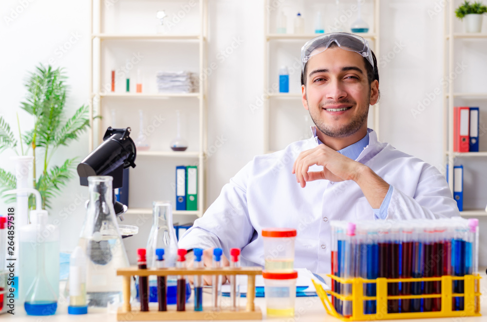 Young male chemist working in the lab 
