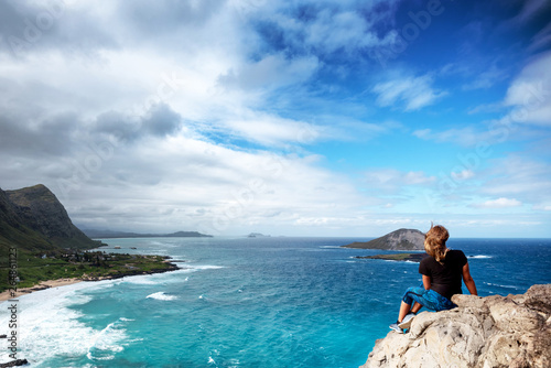 Woman sitting atop a cliff overlooking Oahu, Hawaii's south shore © Allen.G