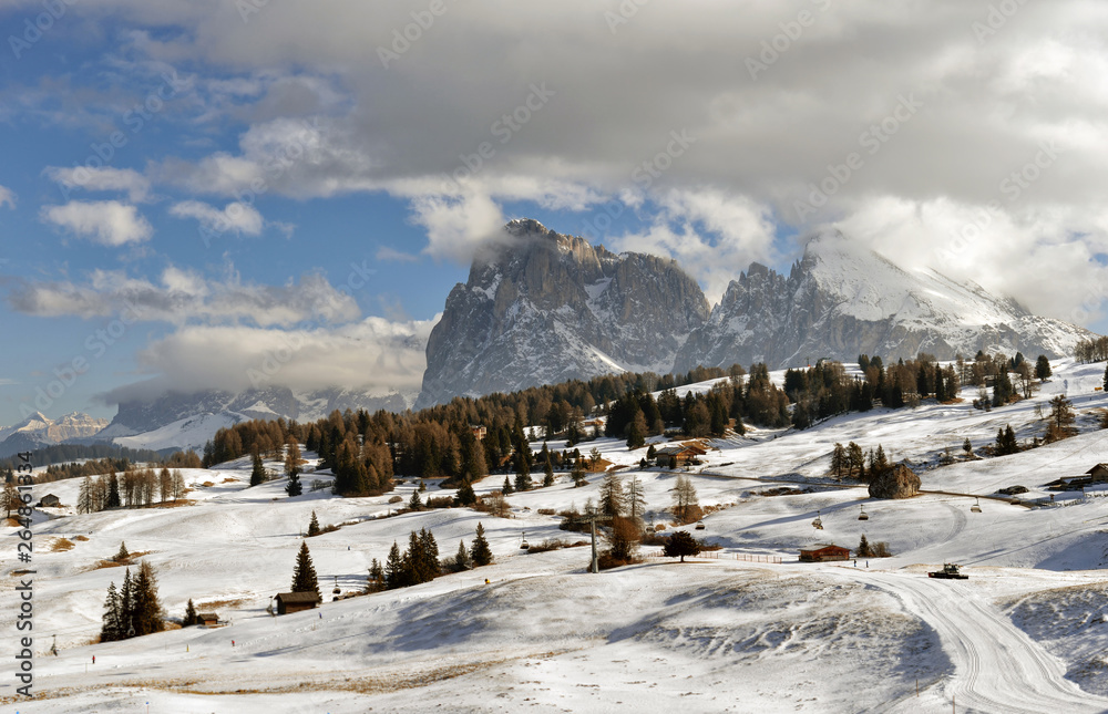 Winter panorama of italian ski resort with background of Seiser Alm, Alpe di Siusi, a high altitude alpine meadow in Dolomites with Langkofel and Plattkofel mountains under snow, South Tyrol, Italy.