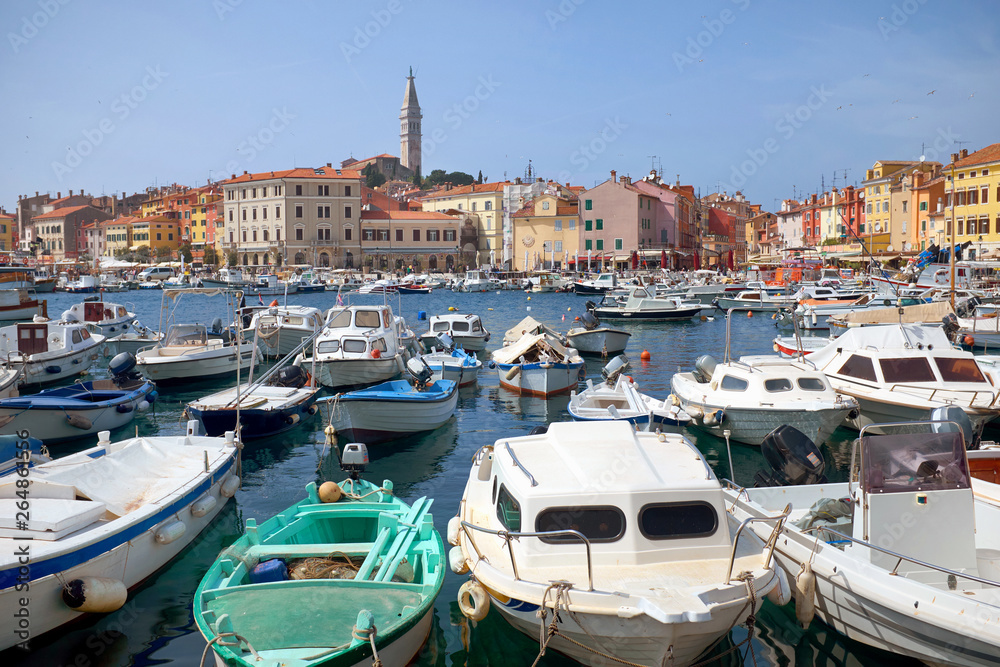 Rovinj harbor with lots of boats in the foreground and the St. Euphemia church’s tower in the background in Istria peninsula.