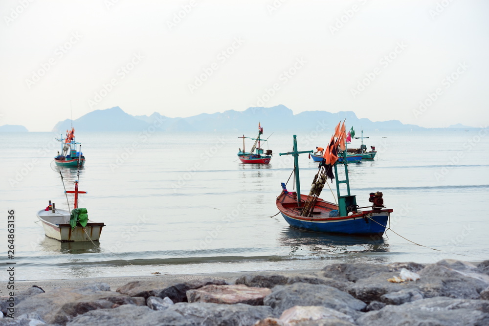 Views at the beach and small fishing boats parked on the beach in the early morning.