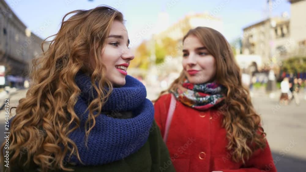 4k.Young pretty women sister twins walk in city street with smile. Steady shot 4k.Young pretty women sister twins walk in city street with smile. Steady shot
