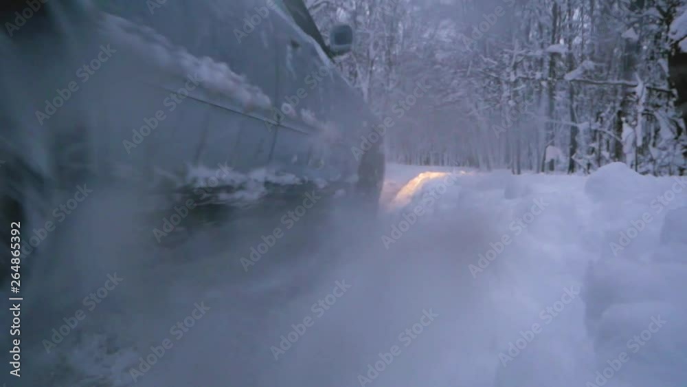 Car slipping in the snow, snow flies from under the wheels to the camera Car slipping in the snow, snow flies from under the wheels to the camera