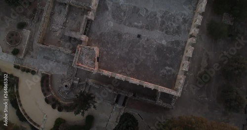 Aerial view of medieval castle Kolossi  and ruins of a former sugar factory.  Dron flying under Crusader stronghold on the south-west of Cyprus at sunset time.  photo
