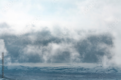 Fantastic view of cloudy mountains landscape with snow.