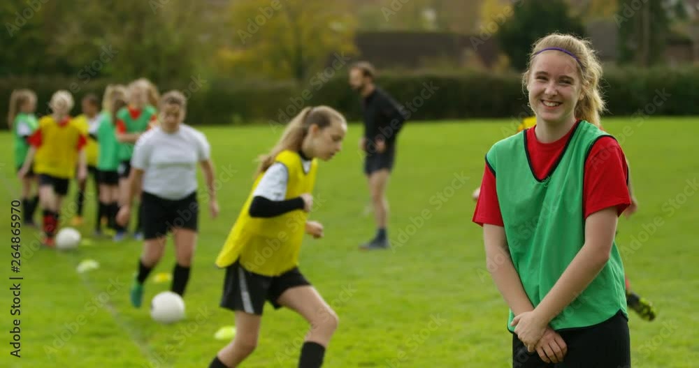4K Portrait smiling girl at soccer training, with team mates training in background. Slow motion. 4K Portrait smiling girl at soccer training, with team mates training in background. Slow motion.