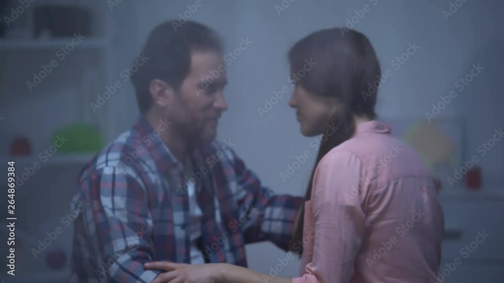Man and woman hugging at room on rainy day, reconciliation after quarrel Man and woman hugging at room on rainy day, reconciliation after quarrel