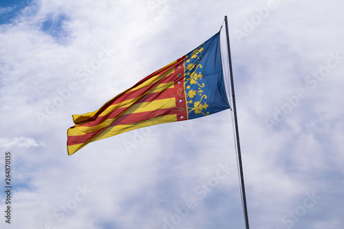 Valencian community flag waving in the wind with blue sky
