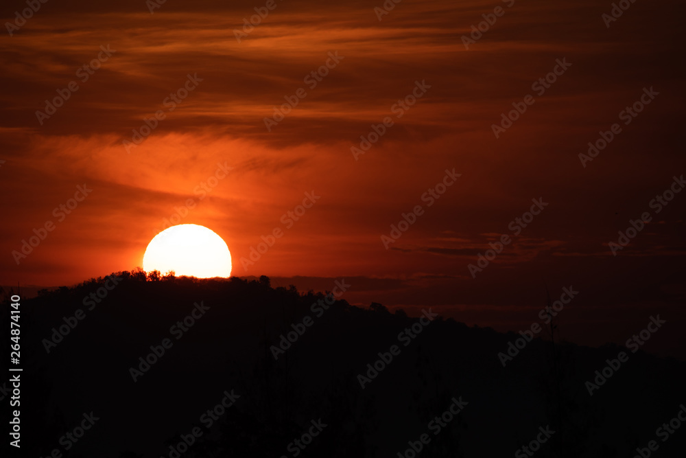 Obraz premium Sun rising from behind the mountain