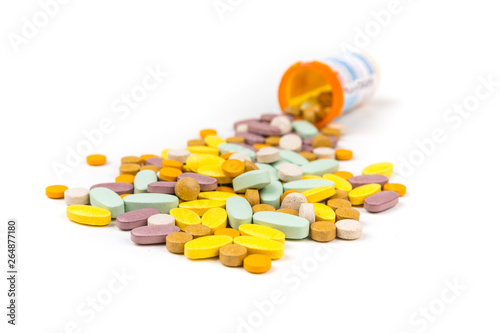 Pile of multicolored pills in front of prescription bottles