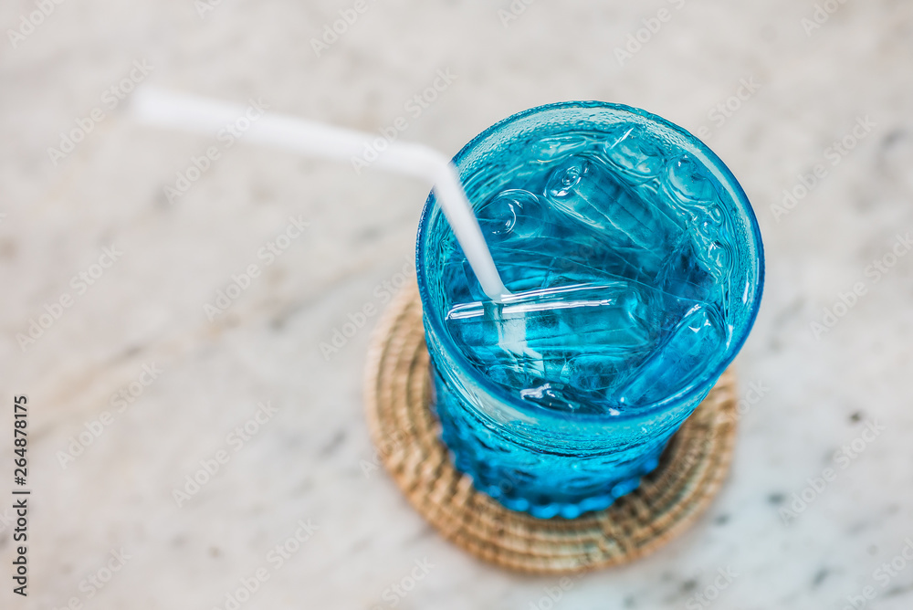blue glass of cold water and plastic straw on the marble table , feel freshness blue glass of cold water and plastic straw on the marble table , feel freshness