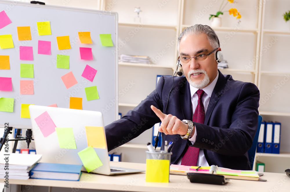 Aged man employee in conflicting priorities concept Aged man employee in conflicting priorities concept