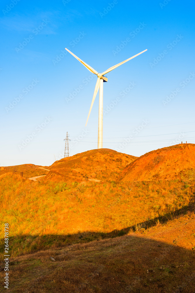 The mountain wind turbines in the sunrise and sunset in the sea of clouds The mountain wind turbines in the sunrise and sunset in the sea of clouds