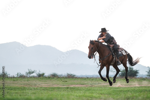 A man in a cowboy outfit with his horse © subinpumsom