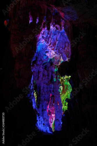 beautiful illuminated multicolored stalactites from karst Reed Flute cave In the cave. Guilin Guangxi China