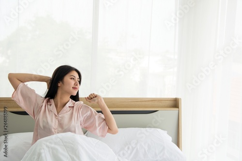 Fotografía Portait of smiling lady wake up stretching herself welcome morning light on the