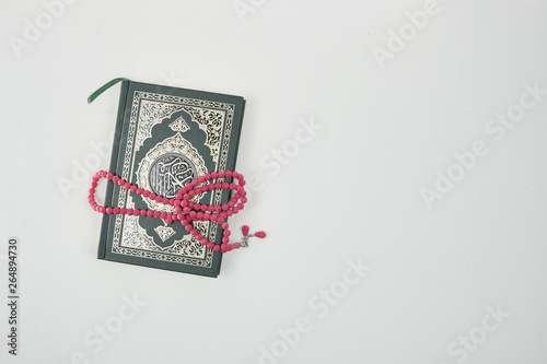 Muslim Holy Quran and rosary or tasbih beads in isolated white.