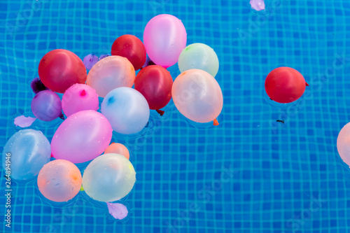 Bild auf Leinwand Globos de colores en el agua de la piscina