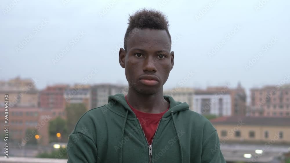 Serious confident young black african migrant staring at acmera-outdoor Serious confident young black african migrant staring at acmera-outdoor