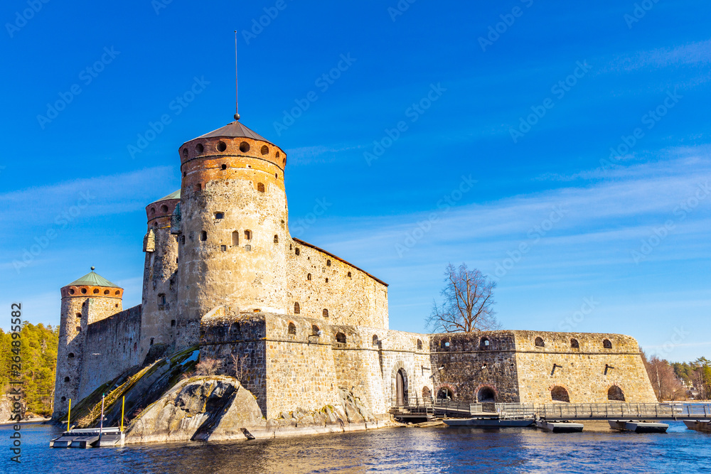 Beautiful view of Olavinlinna, Olofsborg ancient fortress, the 15th-century medieval three - tower castle located in Savonlinna city on a sunny May day. lake Saimaa, Finland.