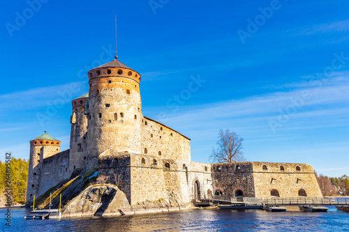 Beautiful view of Olavinlinna, Olofsborg ancient fortress, the 15th-century medieval three - tower castle located in Savonlinna city on a sunny May day. lake Saimaa, Finland. © Alex Shirmanov