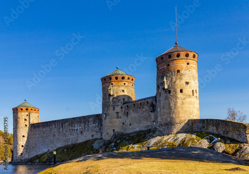 Beautiful view of Olavinlinna, Olofsborg ancient fortress, the 15th-century medieval three - tower castle located in Savonlinna city on a sunny May day. lake Saimaa, Finland.