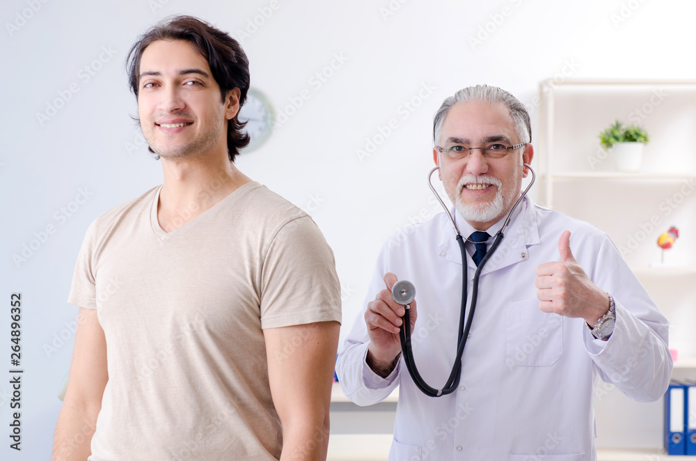Young male patient visiting old doctor Young male patient visiting old doctor