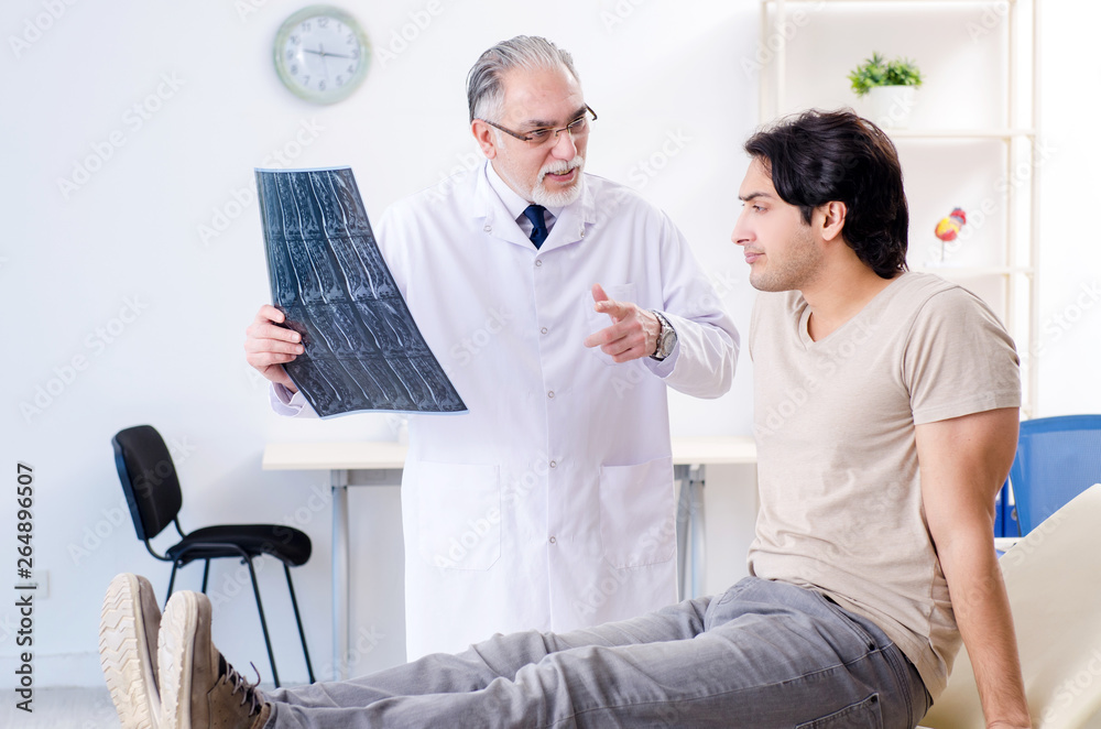 Fototapeta premium Young man visiting old male doctor radiologist 