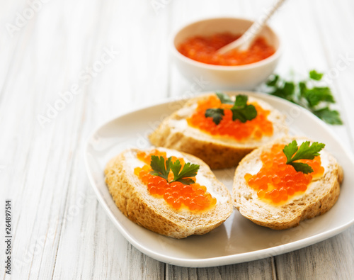 Red caviar in bowl and sandwiches