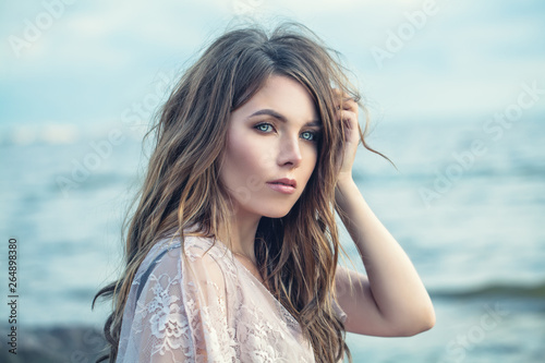 Perfect beauty. Young woman with long hair on blue nature background © millaf