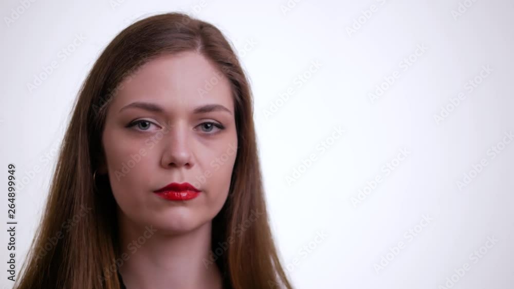 Young brunette woman takes off her glasses and looking at camera on a white background. Young brunette woman takes off her glasses and looking at camera on a white background.