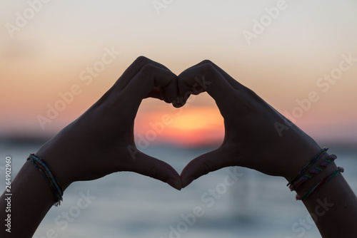 Heart with hands at dawn