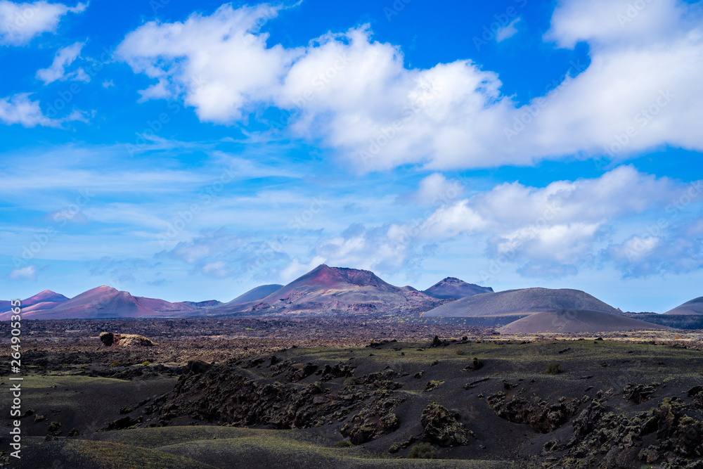 Spain, Lanzarote, Colorful red volcanoes surrounded by endless black solidified lava fields in caldera of timanfaya