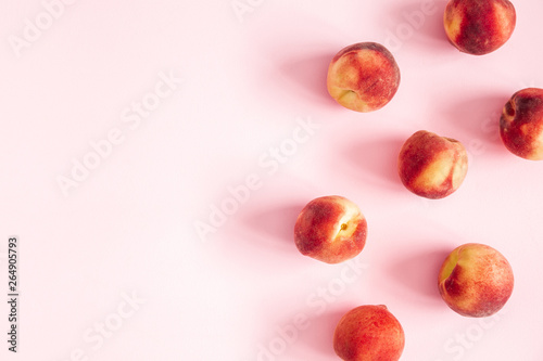 Peaches on pastel pink background. Frame made of fresh peaches. Flat lay, top view, copy space