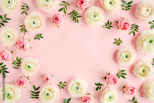 Floral background frame made of pink ranunculus and roses flower buds on pink background.  Flat lay, top view floral background.