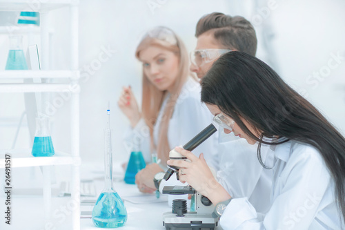 female scientist uses a microscope in the laboratory