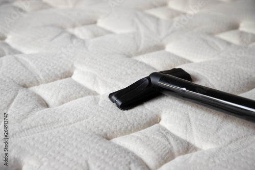 cleaning mattress by vacuum cleaner. dust mites on bed, texture. concept : allergy in bed room. photo