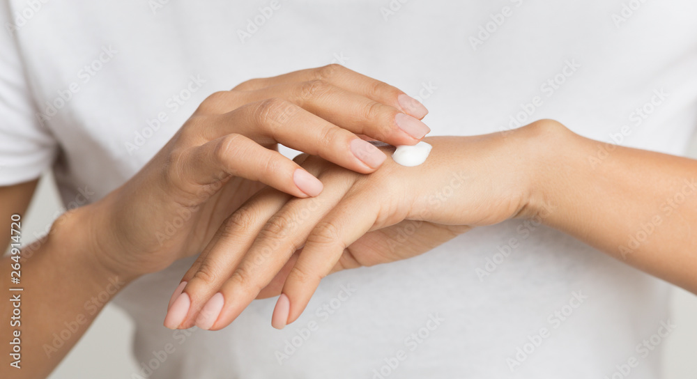 Dot of cream. Woman applying moisturizing hand lotion