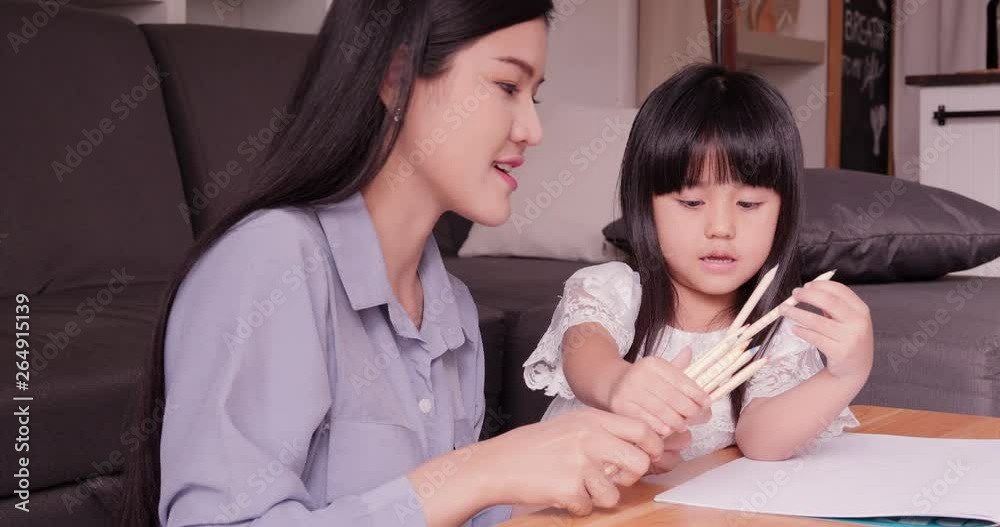Mother having busy time to work and take care her daughter at home. Daughter and her mother having quality time together at home. Mother having busy time to work and take care her daughter at home. Daughter and her mother having quality time together at home.