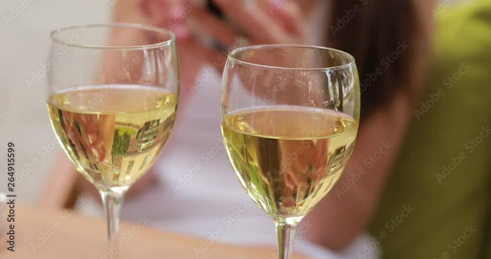 White wine in two glasses, summer and woman on background White wine in two glasses, summer and woman on background
