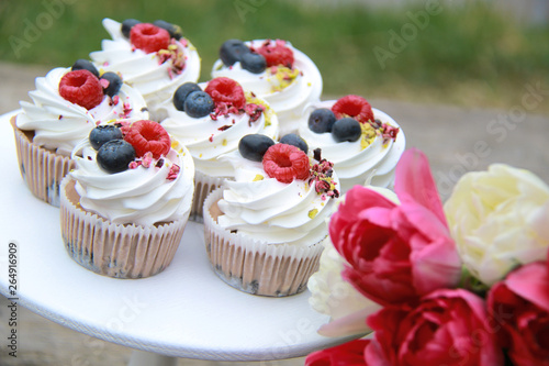 Homemade pavlovas cupcakes with berries and tulips