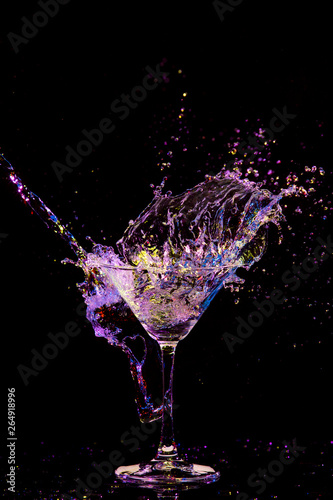 Splash Photography. Burst of Colorful Liquid in Wine Glass. Isolated Over Black Background