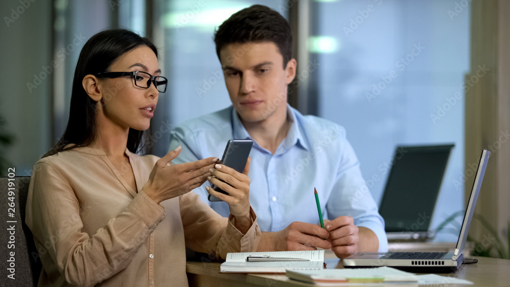 Young freelancers testing smartphone application, modern technology, gadget Young freelancers testing smartphone application, modern technology, gadget