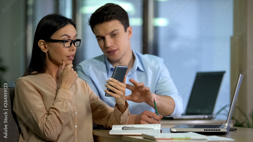 Obraz premium Professional designers discussing core and processor of new smartphone, gadgets