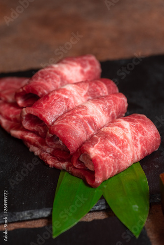 Raw mabled sliced beef on black stone board
