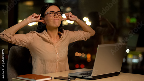Woman covering ears, irritated with noise in office, nervous breakdown at work