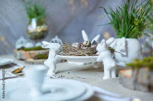 Easter table set. Decorated with eggs, nests and flowers.